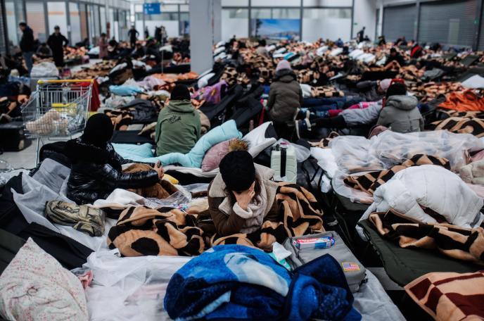 Varias personas descansan en un centro comercial destinado a la acogida temporal de los refugiados, en Polonia.