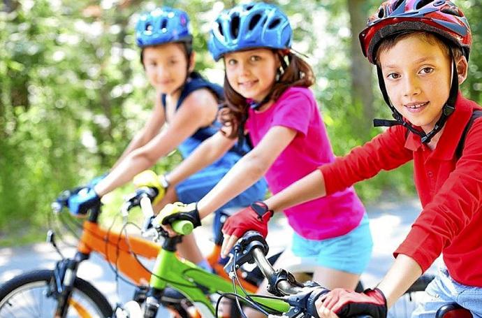 Tres escolares disfrutan de una salida en bicicleta. Foto: Azkoitiko Udala