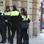 Un agente cachea a un presunto delincuente ante varios compa&ntilde;eros de patrulla.