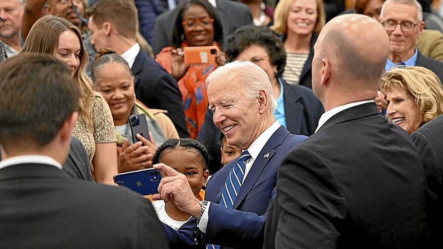 El presidente de EE.UU., Joe Biden, se hace un selfi con una niña en un acto de la campaña electoral. Foto: Afp