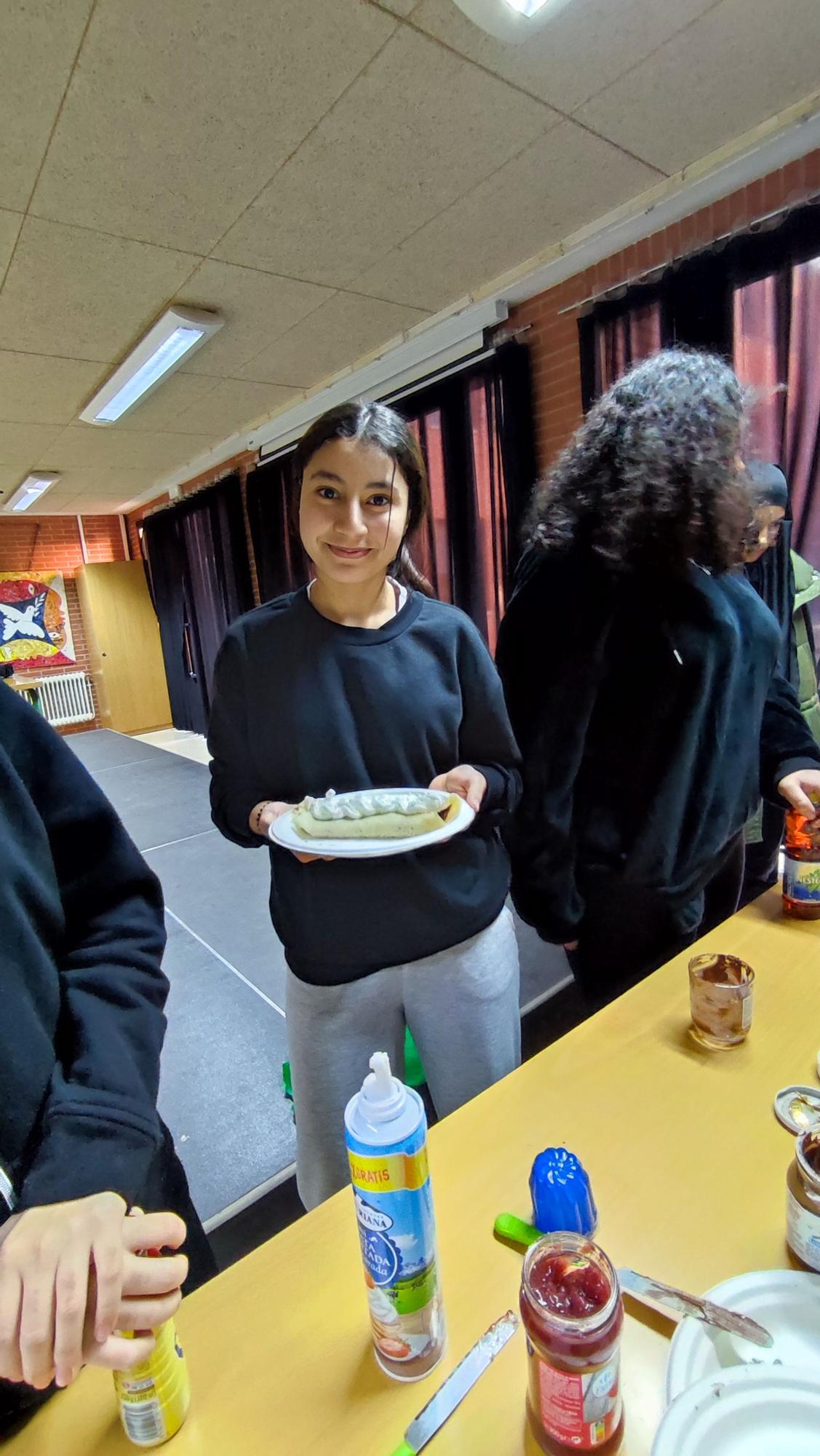 Una alumna con un crepe cubierto de nata.