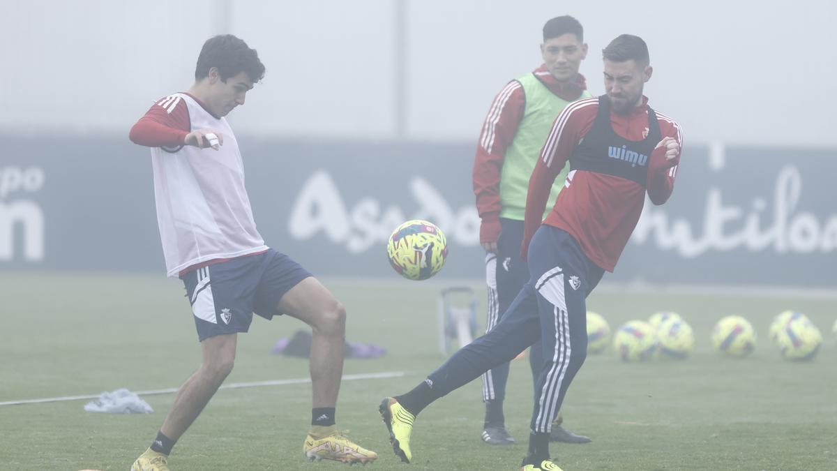 Manu Sánchez y Moi Gómez luchan por un balón ante la mirada de Chimy, en medio de la niebla.