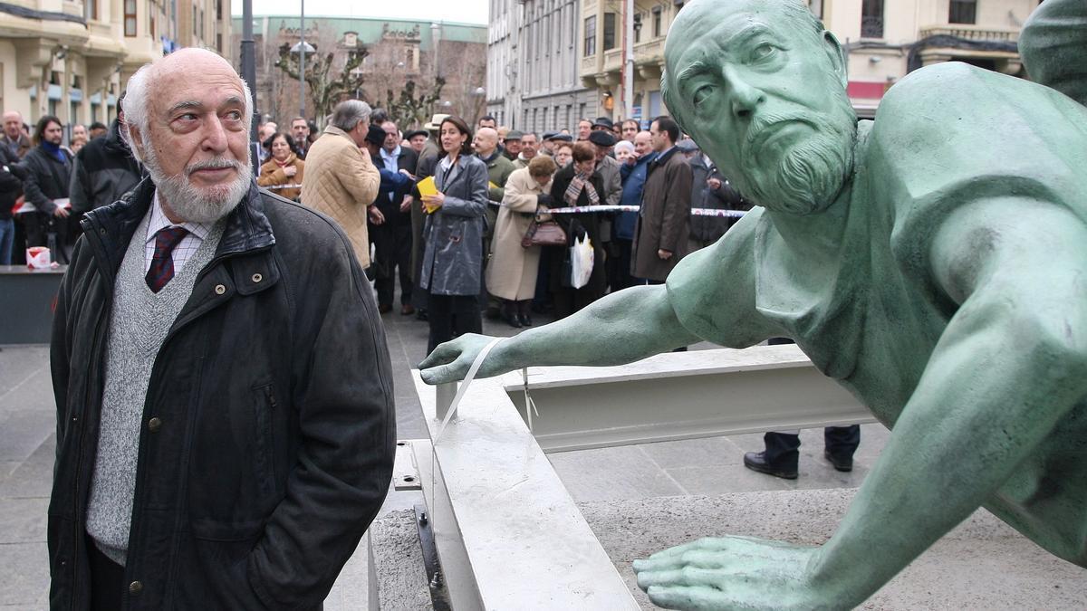 Rafael Huerta, autor de la escultura del Monumento al Encierro, posando junto a un corredor con su rostro durante las obras de montaje e instalación en la avenida de Roncesvalles tras su ampliación.