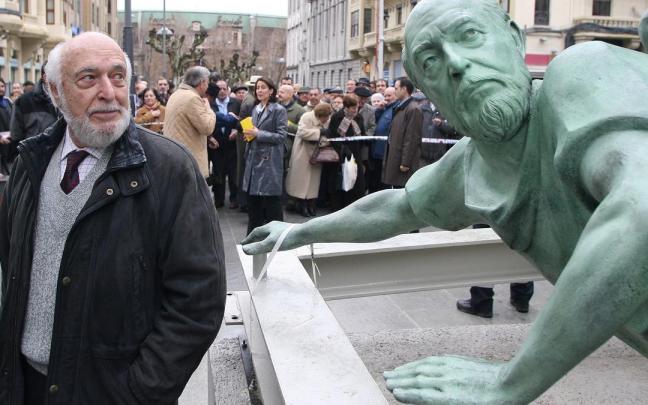 Rafael Huerta, autor de la escultura del Monumento al Encierro, posando junto a un corredor con su rostro durante las obras de montaje e instalación en la avenida de Roncesvalles tras su ampliación.