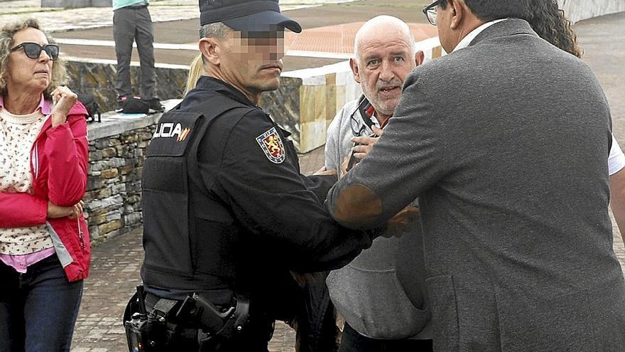 Un hombre es interceptado por la policía tras dar un guantazo a uno de los dos imputados. | FOTO: EFE