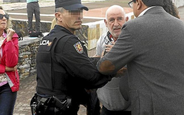 Un hombre es interceptado por la policía tras dar un guantazo a uno de los dos imputados. | FOTO: EFE Un hombre es interceptado por la policía tras dar un guantazo a uno de los dos imputados. | FOTO: EFE