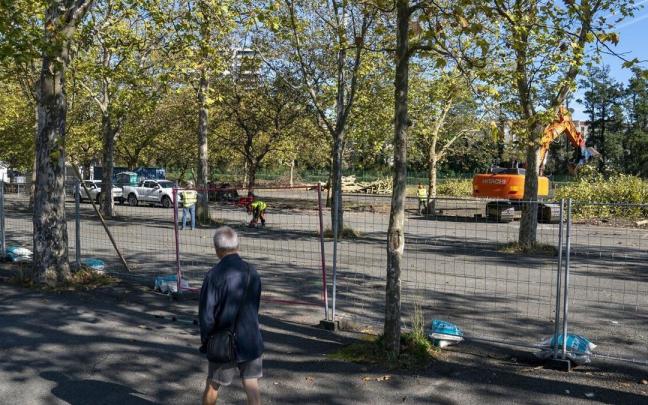 Un hombre camina junto a la zona vallada en la que se construirá el campo de hockey.