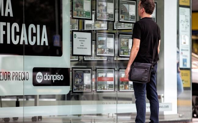 Imagen de archivo de un hombre observando el escaparate de una inmobiliaria con anuncios de pisos en venta y alquiler. Imagen de archivo de un hombre observando el escaparate de una inmobiliaria con anuncios de pisos en venta y alquiler.