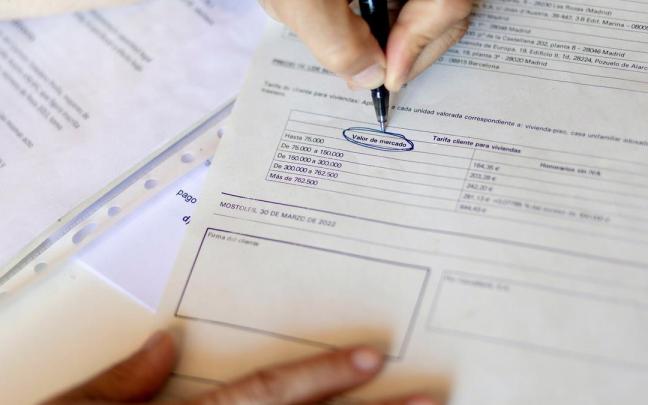 Una mujer se&ntilde;ala el valor de mercado de una escritura de compraventa de una hipoteca.