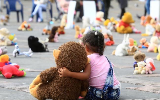 Una niña abraza un muñeco durante una protesta contra del abuso sexual infantil Una niña abraza un muñeco durante una protesta contra del abuso sexual infantil
