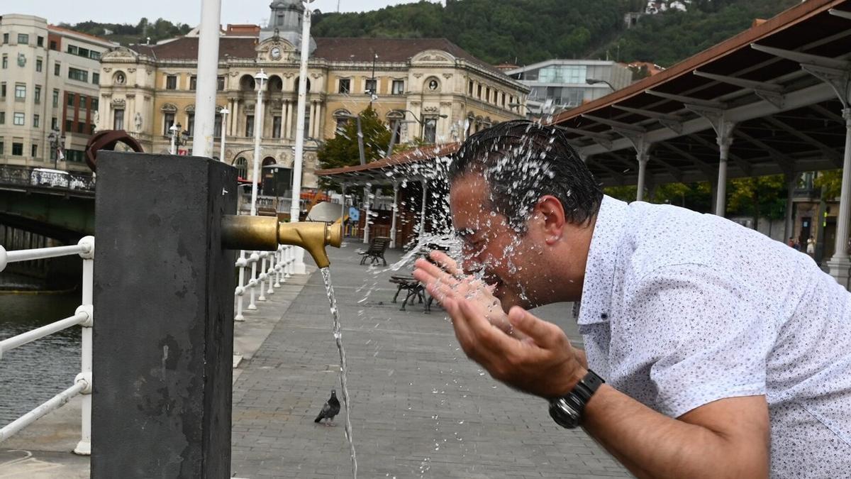 Un hombre se refresca en una fuente de Bilbao para sobrellevar la elevadas temperaturas que dejó el verano en Bizkaia.