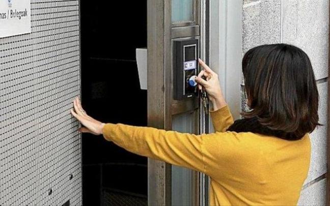 Una trabajadora ficha al entrar en su oficina. Una trabajadora ficha al entrar en su oficina.
