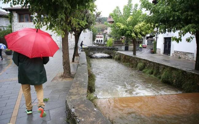 Un hombre se protege de la lluvia en Lesaka Un hombre se protege de la lluvia en Lesaka