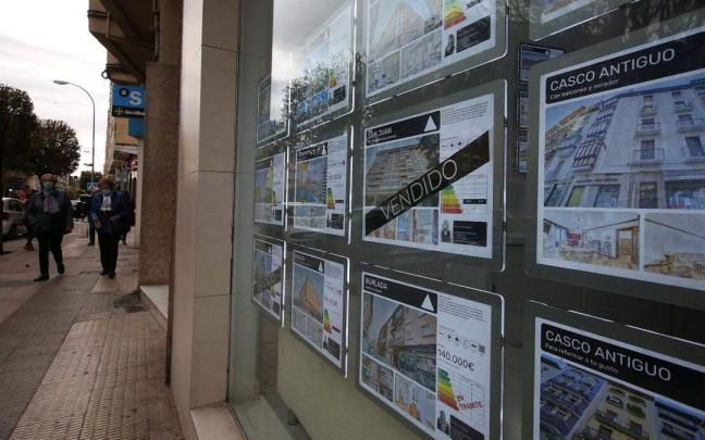 Escaparate de una inmobiliaria con anuncios de pisos en venta y alquiler.