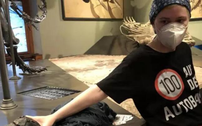 Ecologistas pegan sus manos al pedestal de un esqueleto de dinosaurio de un museo de Viena.