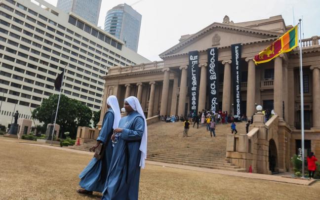 Dos monjas pasean ante el edificio de la Secretaría Presidencial en Colombo, Sri Lanka. Dos monjas pasean ante el edificio de la Secretaría Presidencial en Colombo, Sri Lanka.