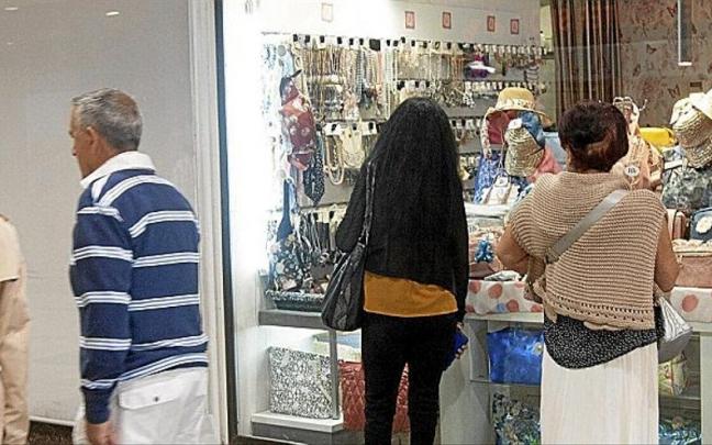 Varias personas pasean y observan un escaparate en el centro de Vitoria-Gasteiz.