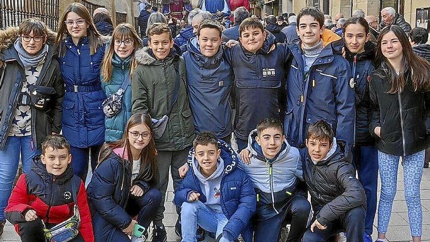 Un grupo de 6º de primaria posa, guardando las monedas en la mano.