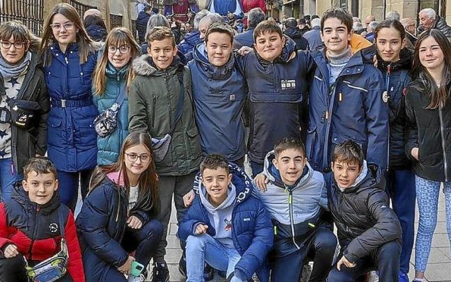 Un grupo de 6º de primaria posa, guardando las monedas en la mano.