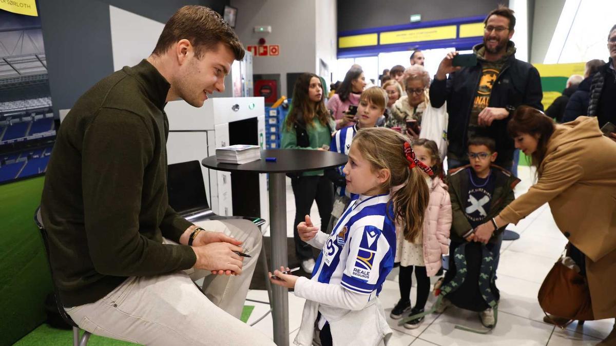 Sorloth conersa con una jovencísima aficionada txuri-urdin durante el acto de esta tarde.