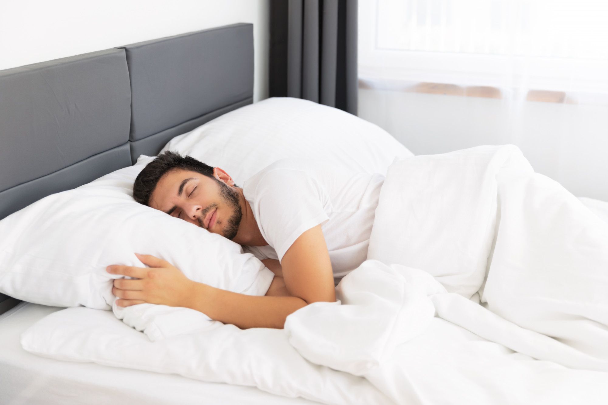 Un hombre echa la siesta en una cama.