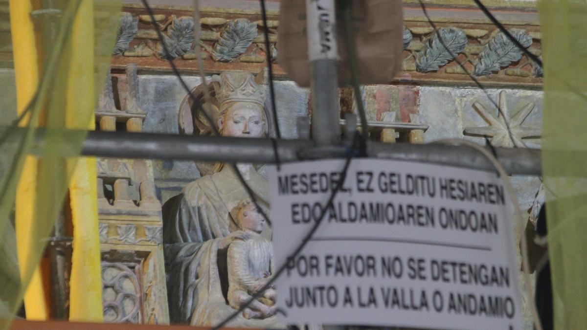 Figuras policromadas del pórtico de la parroquia ocultas tras los andamios de obra.