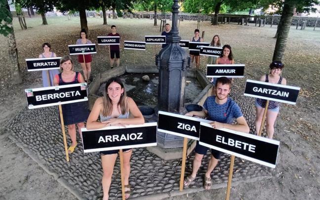 Miembros de la asociación Baztandarren Biltzarra en Merkatu Zelai, con los carteles que utilizan los pueblos en el desfile de carrozas