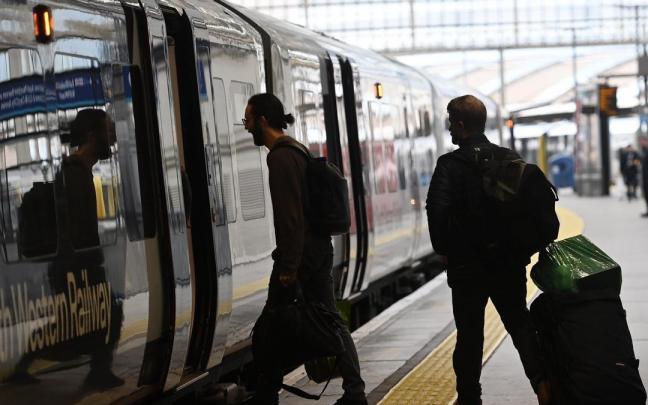 Dos hombres se suben a un tren en la estación londinense de Waterloo. Dos hombres se suben a un tren en la estación londinense de Waterloo.