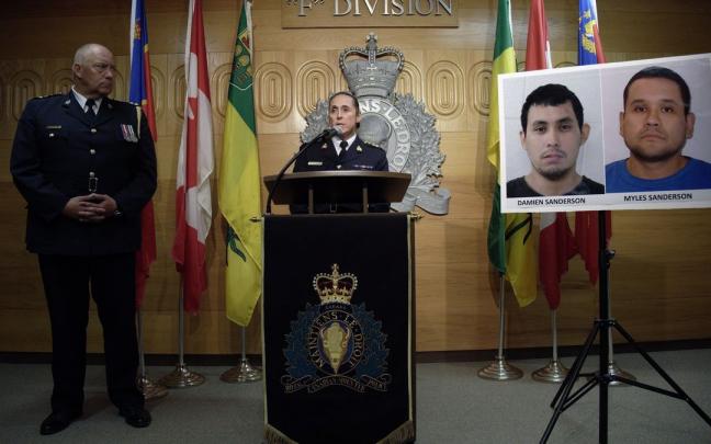 Policías canadienses junto a las imágenes de Damien y Myles Sanderson.