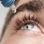 Un joven se hidrata los ojos con gotas. Un joven se hidrata los ojos con gotas.