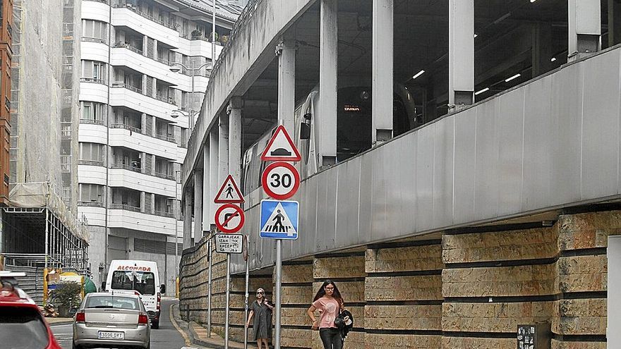 Vehículos circulan a la altura del Consistorio, con un tren llegando a la estación de Ardantza.