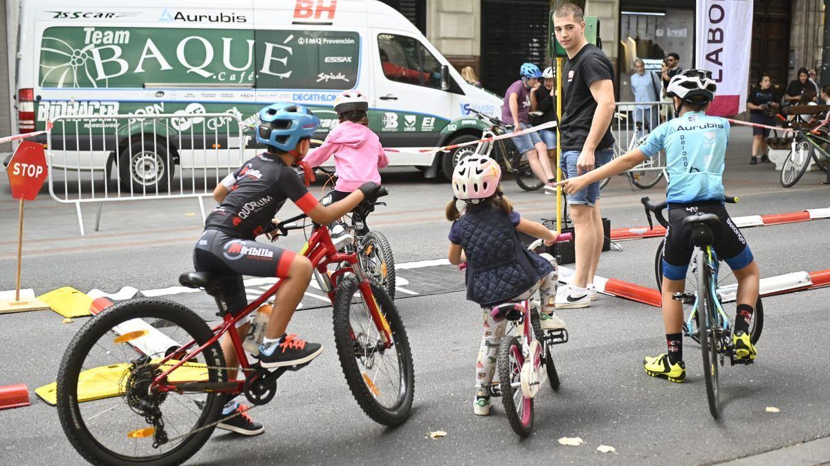 Varios niños y niñas circulan en bicicleta por un circuito creado en la Gran Vía de Bilbao