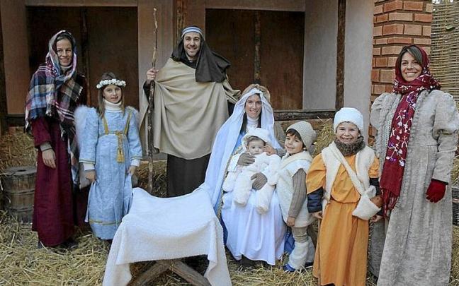 El nacimiento rodeado de pastores y del ángel.