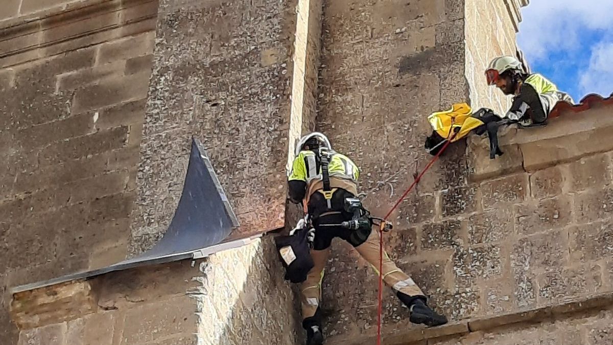 Bomberos descolgándose para retirar una chapa