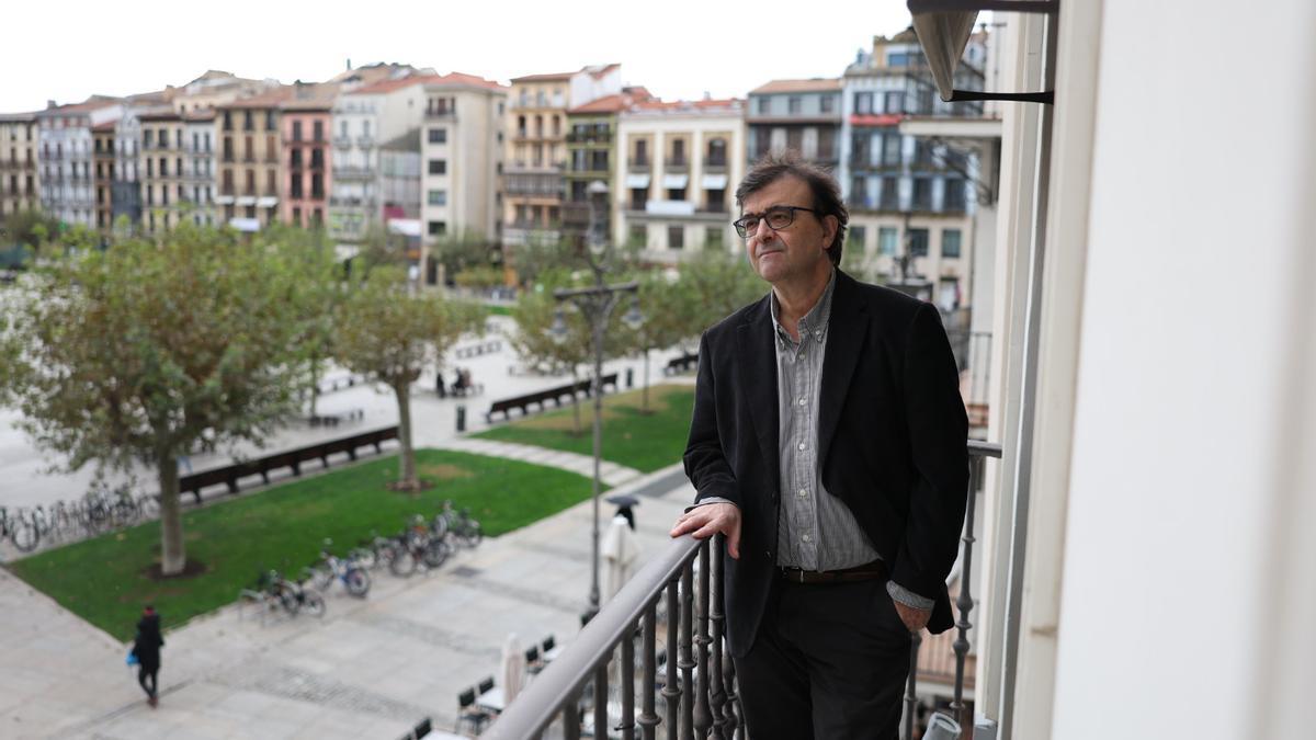 Javier Cercas se asoma a la Plaza del Castillo desde la habitación Sarasate del Hotel La Perla.