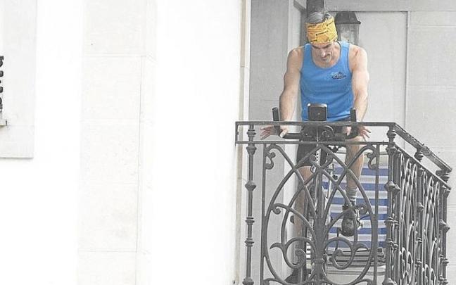Un vecino haciendo deporte en el balcón durante el confinamiento.