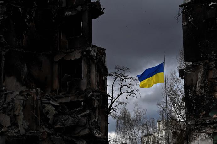 Una bandera ucraniana ondea entre edificios destruidos en la región de Kiev.