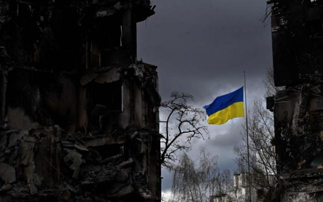 Una bandera ucraniana ondea entre edificios destruidos en la región de Kiev.