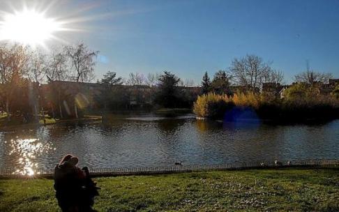 Una pareja aprovecha los últimos rayos de sol para ver los patos en el Lago de Barañáin, enclave verde y tranquilo con el que cuenta la localidad.