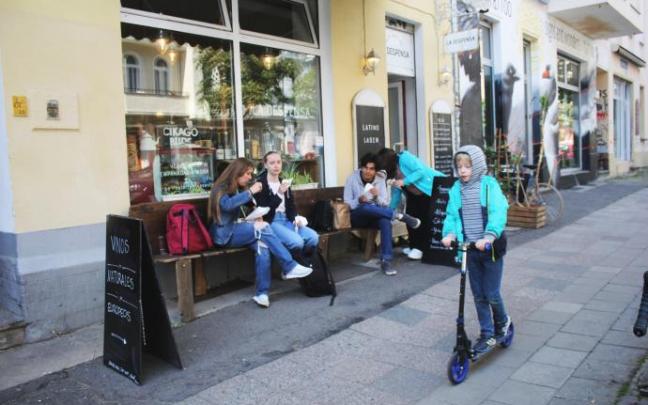 Un grupo de personas comen en los bancos de un bar-tienda en Berlín. Un grupo de personas comen en los bancos de un bar-tienda en Berlín.