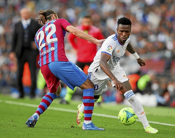 Vinicius intenta superar a Mingueza, defensa del Barcelona.