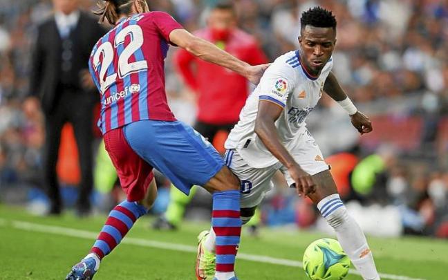 Vinicius intenta superar a Mingueza, defensa del Barcelona.