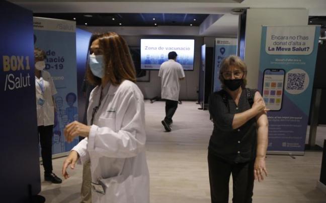 Una mujer se lleva la mano al brazo tras recibir la vacuna contra el covid en Barcelona.