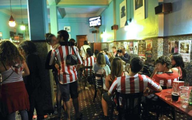 Varias personas siguen un partido del Athletic en un bar. Varias personas siguen un partido del Athletic en un bar.