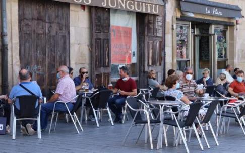Personas sentadas en la terraza de un bar con mascarilla para evitar contagios de coronavirus.