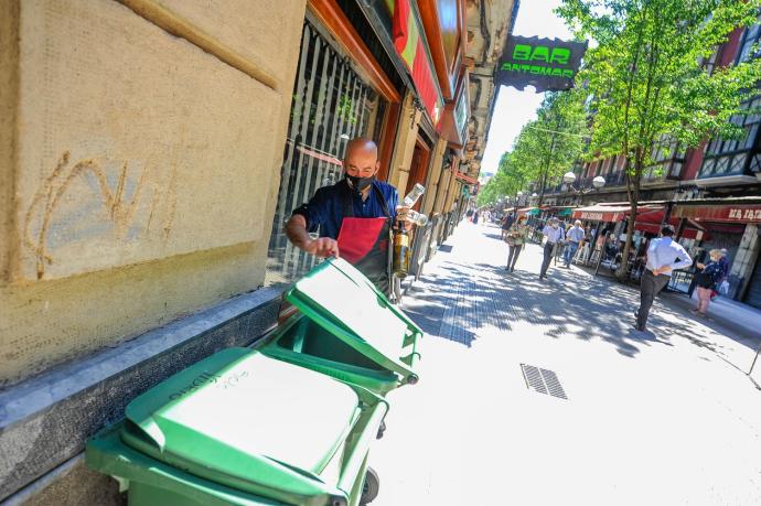 Un hostelero deposita envases de vidrio en contenedores específicos