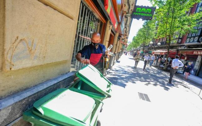 Un hostelero deposita envases de vidrio en contenedores específicos Un hostelero deposita envases de vidrio en contenedores específicos