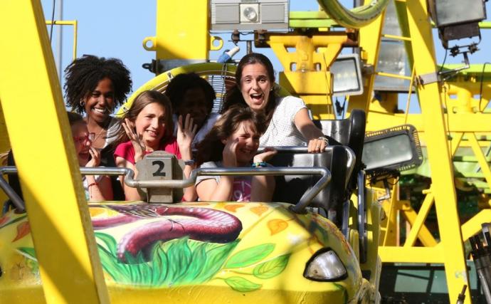 Varias personas disfrutan de una atracción de feria en unas fiestas de San Fermín.