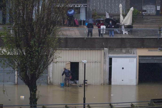 Un vecino de Basauri comprueba el estado de las lonjas inundadas al desbordarse el río Nervión