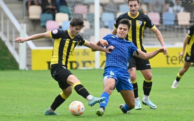 Jon Urkiza, jugador del Barakaldo, intenta centrar ante la oposición de Aitzol González en el derbi ante el Portu en Lasesarre. Jon Urkiza, jugador del Barakaldo, intenta centrar ante la oposición de Aitzol González en el derbi ante el Portu en Lasesarre.
